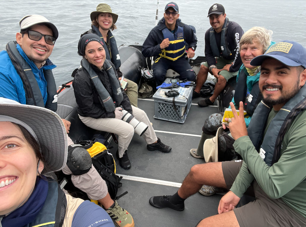Researchers smiling in an inflatable boat